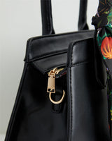 Schwarze Handtasche mit botanischem Kürbis-Print