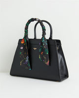 Schwarze Handtasche mit botanischem Kürbis-Print