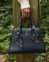 Schwarze Handtasche mit botanischem Kürbis-Print